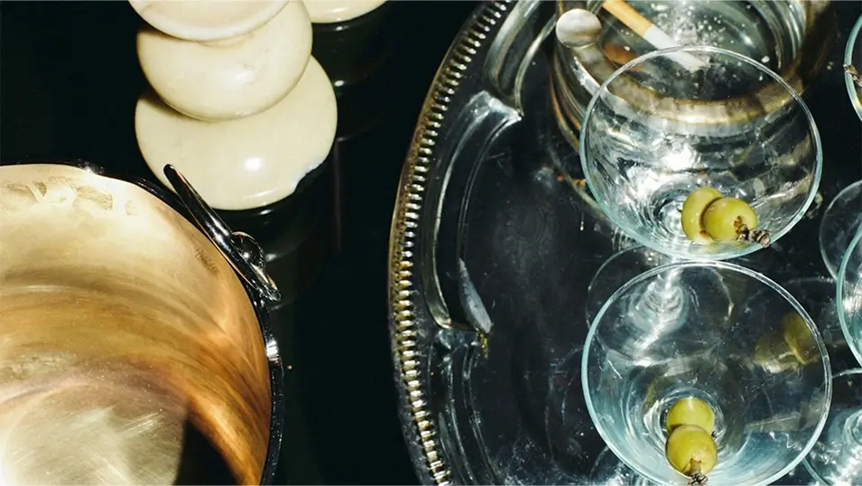 Luxury event production featuring martini glasses on a silver tray and brass decor